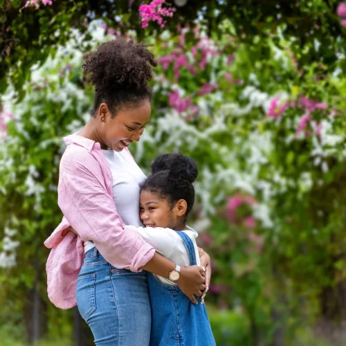 Mom and daughter hugging happily.