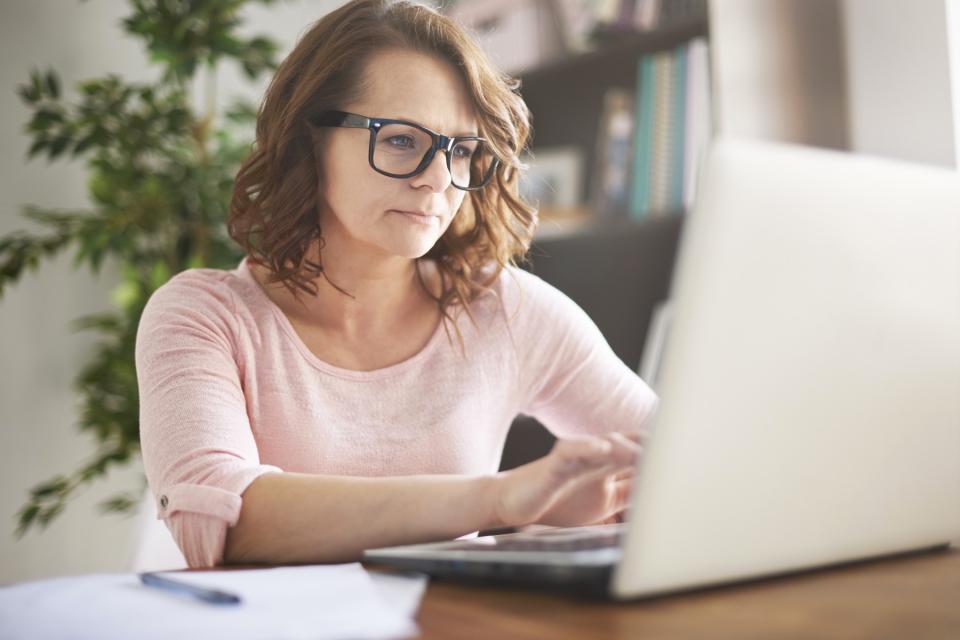 Woman works on her computer at her desk. 