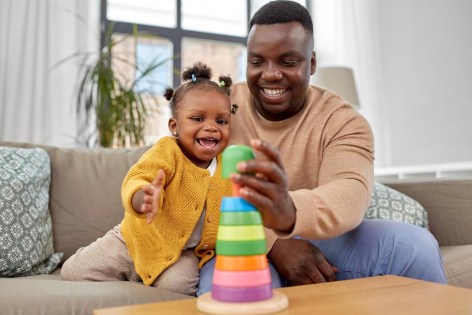 Dad and daughter playing with a ring toy. 