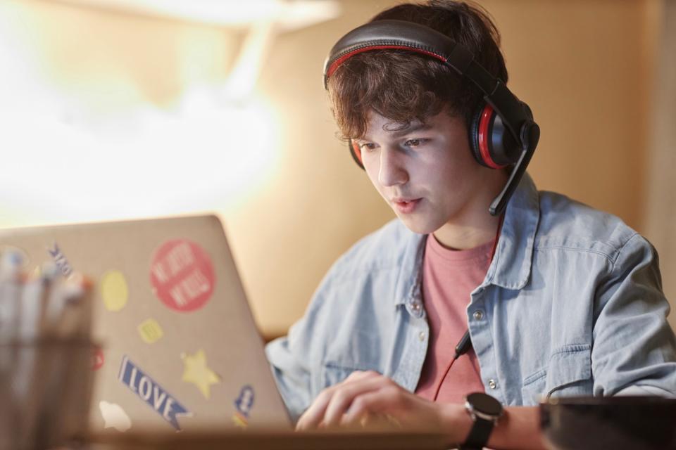 Boy playing games on his laptop.