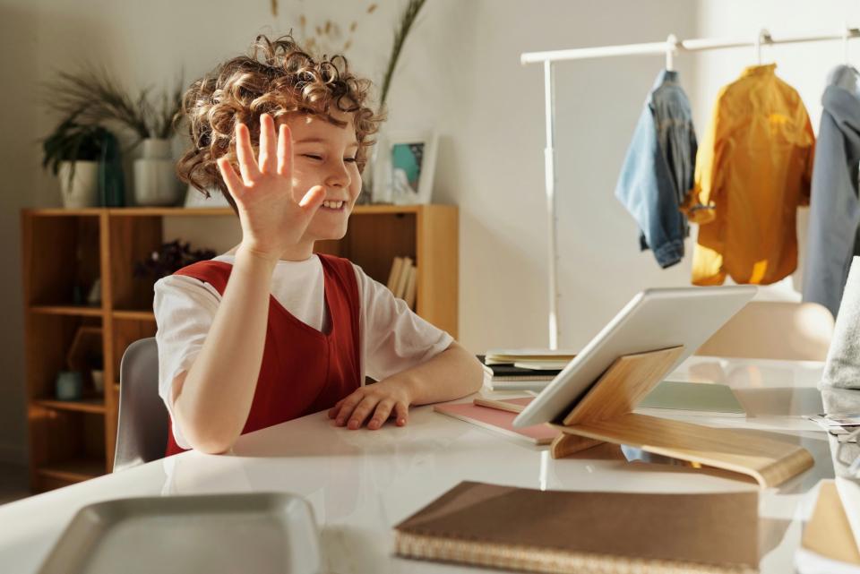 Child on a video call, waving