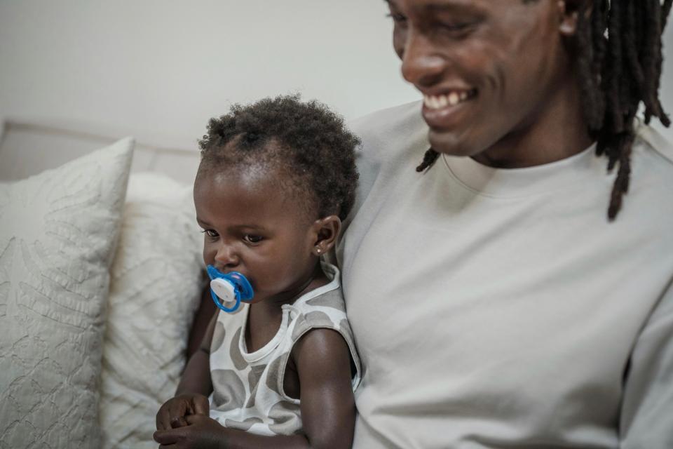 Dad and baby daughter sitting on couch